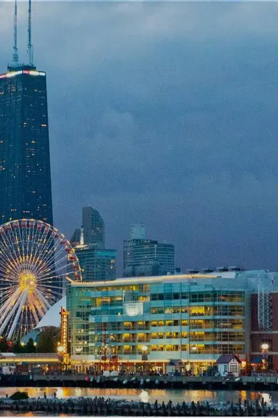 Navy Pier and Centennial Wheel lit at dusk with the Chicago skyline. 